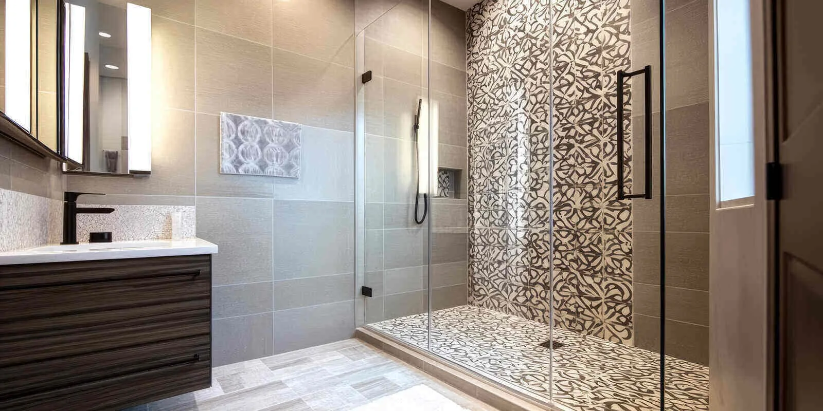 Glass walk-in shower with patterned tile and a floating vanity