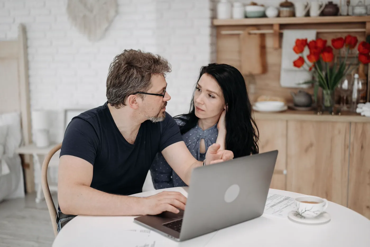 Couple planning on a laptop in their kitchen
